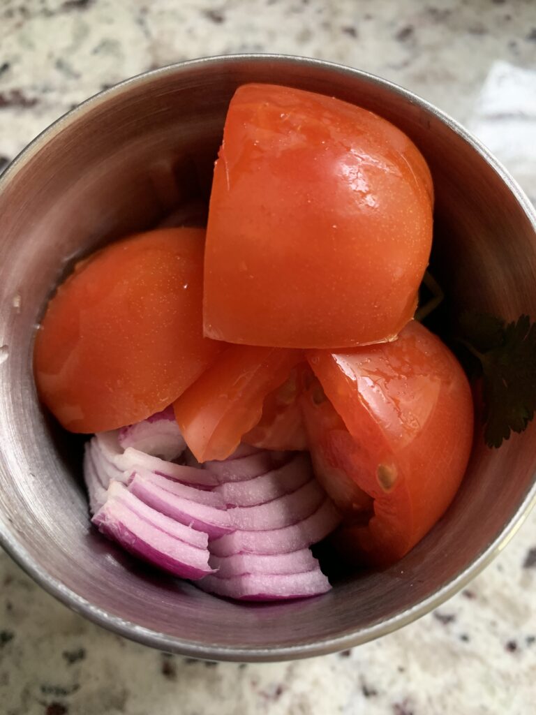 add onion tomato, ginger, garlic coriander leaves with stems and green chilies to the grinder